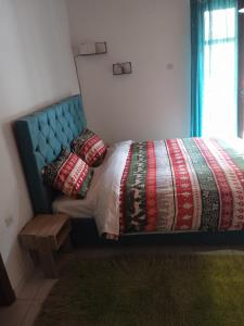 a bedroom with a bed with a blue headboard and pillows at Breakfast & Snacks, 2bedrooms 2bathrooms House in Kato Zachlorou