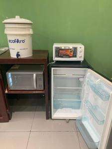 an open refrigerator with a toaster oven on top of it at Q´ojoom Jaay in San Juan La Laguna