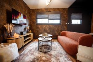 ein Wohnzimmer mit Sofa und Tisch in der Unterkunft * L’Eden * Maison romantique avec balnéo et sauna in Treize-Vents