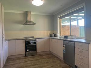 an empty kitchen with a stove and a window at 39onDewhurst in Mudgee