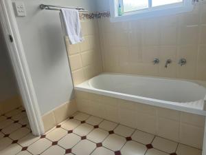 a white bath tub in a bathroom with a window at 39onDewhurst in Mudgee