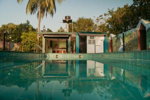 a house with a swimming pool next to a palm tree at Silent valley nest in Nachinola