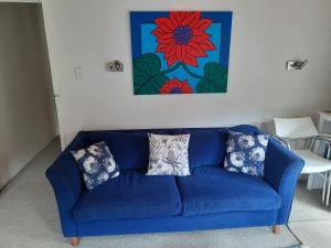 ein blaues Sofa mit Kissen im Wohnzimmer in der Unterkunft Akatarawa Valley Retreat a Cosy Two Bedroom Guest Suite in Upper Hutt