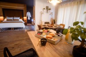 Zimmer mit einem Bett und einem Tisch mit einem Tablett mit Essen in der Unterkunft * L’Eden * Maison romantique avec balnéo et sauna in Treize-Vents + 20 Fotos