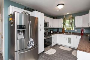 a kitchen with a stainless steel refrigerator and white cabinets at Family Friendly Home Close to Airport and Downtown in Des Moines