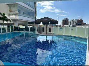 een zwembad met een parasol bovenop een gebouw bij Excelente Cobertura Duplex in Cabo Frio