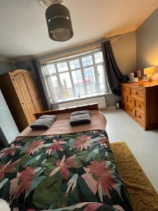 een slaapkamer met een bed en een groot raam bij House near to CastleCourt shopping in Belfast