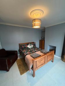een slaapkamer met een bed, een bank en een lamp bij House near to CastleCourt shopping in Belfast