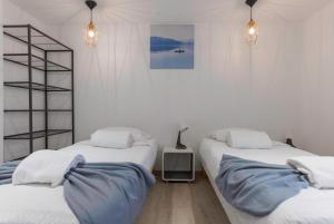 2 Betten in einem Zimmer mit weißen Wänden in der Unterkunft "Casa Nonna" - 16 mn à pied du Palais, parking privé, clim, ascenseur in Cannes