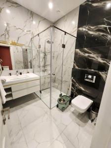 a bathroom with a shower and a toilet and a sink at Awesome Brand New Apartment, In Center in Yerevan +12 photos