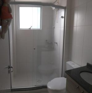 een badkamer met een douche, een toilet en een raam bij Pe na areia in Florianópolis