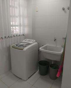 een witte badkamer met een wastafel en een toilet bij Pe na areia in Florianópolis