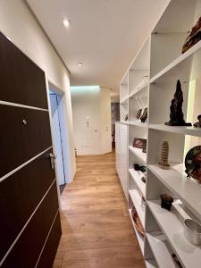 a room with a hallway with white shelves and a door at Center Apartment Easy in Tirana