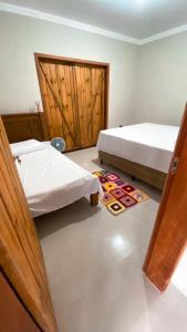 a bedroom with two beds and a rug on the floor at Recanto Tereza Dias in Lagoinha