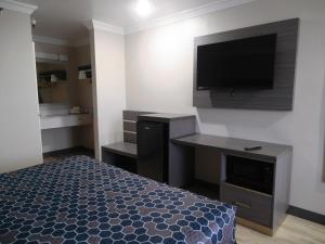 a bedroom with a bed and a flat screen tv at Americas Best Value Inn-Rialto in Rialto