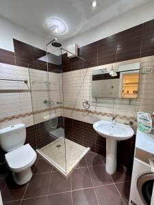 a bathroom with a toilet and a sink and a shower at Center Apartment Easy in Tirana
