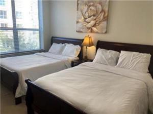 a bedroom with two beds and a lamp in it at Gorgeous Furnished Apartments near Texas Medical Center & NRG Stadium in Houston