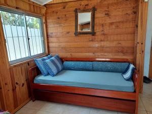 Cama en habitación con pared de madera en Hermosa cabaña totalmente equipada en barra del Chuy, en Barra del Chuy