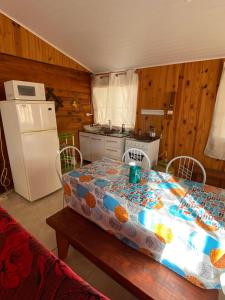 cocina con mesa y mantel con flores en Hermosa cabaña totalmente equipada en barra del Chuy, en Barra del Chuy