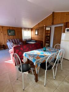 een woonkamer met een tafel en stoelen en een bank bij Hermosa cabaña totalmente equipada en barra del Chuy in Barra del Chuy