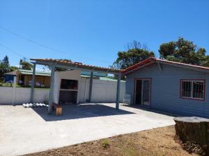 una casa azul con un pabellón en un patio en Hermosa cabaña totalmente equipada en barra del Chuy en Barra del Chuy