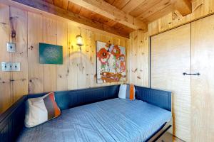 ein kleines Bett in einem Zimmer mit Holzwänden in der Unterkunft Rockport Sunday in Rockport