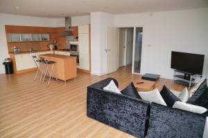 a living room with a couch and a kitchen at SECC Ovo Apartments in Glasgow