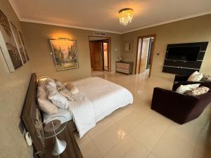 Habitación grande con cama y TV. en Appart Luxe 5* de 180m² + Vue imprenable sur Oran, en Orán