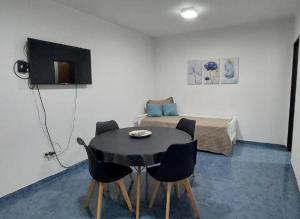 a room with a black table and chairs and a bed at Departamento Falucho 2 in Santa Rosa