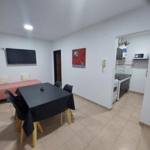 een woonkamer met een tafel en een keuken bij Departamento Falucho 1 in Santa Rosa