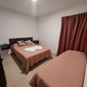 een slaapkamer met 2 bedden en een rood gordijn bij Departamento Falucho 1 in Santa Rosa
