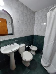 een badkamer met 2 toiletten, een wastafel en een spiegel bij Departamento Falucho 1 in Santa Rosa