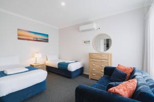 a hotel room with two beds and a couch at Amalfi Resort in Busselton