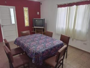 een eetkamer met een tafel met stoelen en een televisie bij Mi Recreo in Villa Cura Brochero