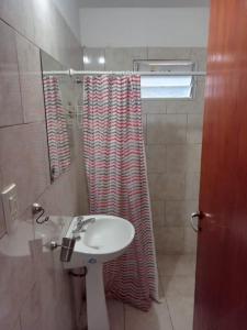 een badkamer met een wastafel en een douchegordijn bij Mi Recreo in Villa Cura Brochero