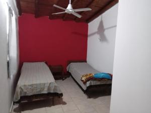 een slaapkamer met twee bedden en een plafondventilator bij Mi Recreo in Villa Cura Brochero