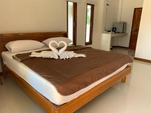 un letto con due cigni fatti di asciugamani di Sisters Home ที่พักใกล้สวนพฤกษศาสตร์ ระยองแหลมแม่พิมพ์ a Ban Ko Kok