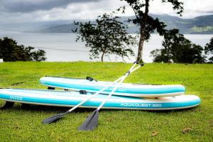 dos kayaks sentados en la parte superior de un campo de hierba en Hotel Little Paradise, en Nuevo Arenal