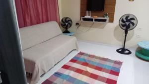 Habitación con cama y alfombra en el suelo en Residencial Margaridas ap 1, en Porto Seguro