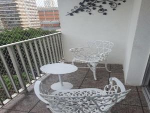 a balcony with a table and a chair and a table at Conforto e Comodidade in São Paulo