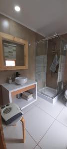 y baño con ducha acristalada y lavamanos. en Condominio Don Alberto, en Pichilemu