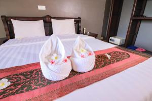 Zwei Körbe mit Blumen sitzen auf einem Bett in der Unterkunft Riviera Hotel & Resort Kep in Kep