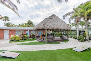 a gazebo with a bench and a grass roof at Siesta Key Beachside Villas in Sarasota