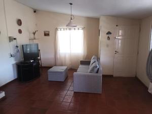 ein Wohnzimmer mit einem Sofa und einem TV in der Unterkunft Casa La Nona in Estancia Vieja