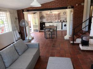 ein Wohnzimmer mit einem Sofa und einer Küche in der Unterkunft Casa La Nona in Estancia Vieja