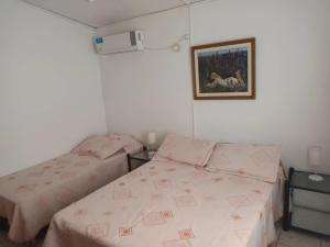 ein Schlafzimmer mit 2 Betten und einem Bild an der Wand in der Unterkunft Casa La Nona in Estancia Vieja