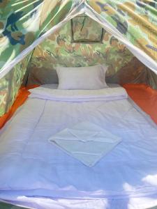 a bed in a tent with a shirt on it at Plankton Bungalow and Camping in Koh Rong Island