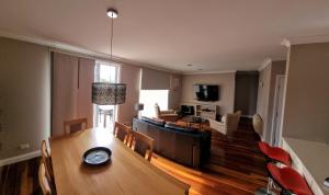 uma sala de estar com uma mesa de jantar e um sofá em 2 Bedroom Villa @ Oaks Cypress Lakes Resort em Pokolbin