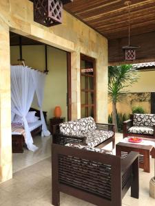 une terrasse avec des canapés et un lit dans une chambre dans l'établissement Ocean Beachfront Villa Dini, à Banjar