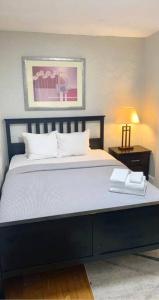 a bedroom with a large bed with a black frame at The House Hotels - Lark 1 in Lakewood